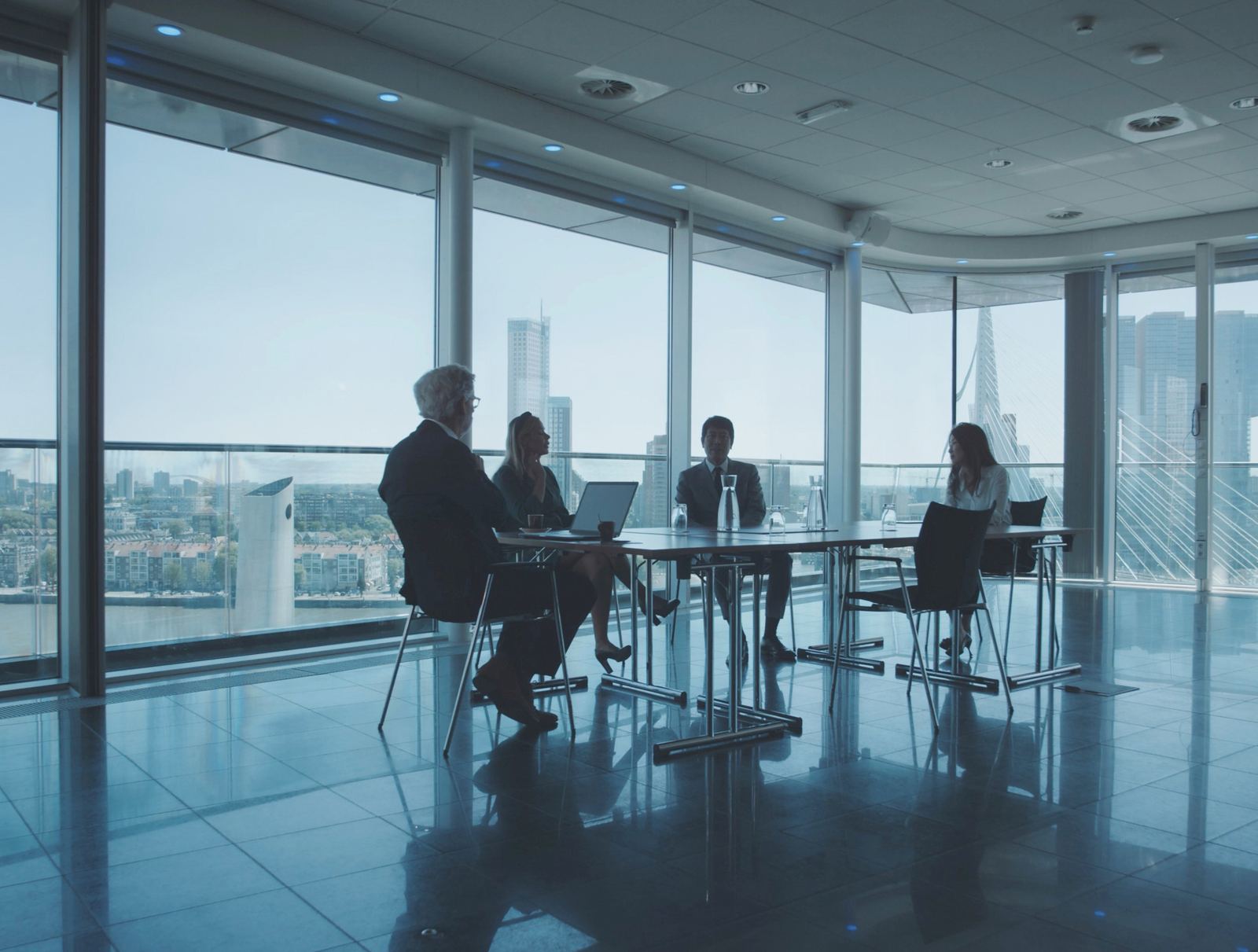 A leadership team meeting in a glass conference room